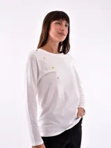 Remera manga larga color lila con cuello redondo y detalle de botones dorados en el hombro.