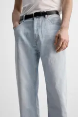 Pantalón de jean gris de corte recto, con cinco bolsillos, efecto lavado y cierre frontal con botones.
