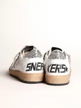 Zapatillas Golden Goose Ball Star de cuero blanco con estrella plateada brillante, refuerzo trasero plateado brillante, cordones grises y suela color caramelo.