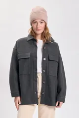 Sobrecamisa de paño color gris oscuro, con cuello camisero, cierre frontal con botones, dos bolsillos de parche con solapa en el pecho y corte holgado.