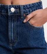 Short de jean azul oscuro, corte mom, tiro alto, con bolsillos delanteros y traseros, y cintura con trabillas.