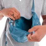 Bolso bandolera Nike Aura Crescent color celeste, con logo blanco estampado.