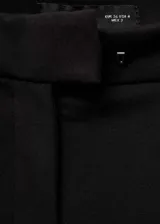Pantalón negro de vestir, de corte recto, con cierre de cremallera y gancho, tiro medio, trabillas y bolsillos laterales y traseros.