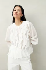 Camisa negra de tencel liviana con volados románticos y manga corta.