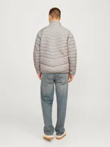Campera puffer gris de manga larga con cuello alto y cierre frontal con cremallera.