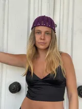 Gorro de crochet color violeta con tachas plateadas alrededor del borde.