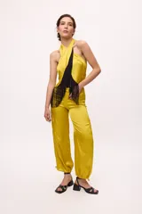 Pantalón negro traslúcido con corte ancho y ajuste en los tobillos.