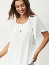 Blusa blanca de mangas cortas con escote redondo y lazos.