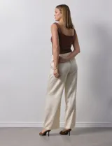 Pantalón palazzo color crema, marca Nanette, con pretina elastizada, lazo de ajuste y bolsillos delanteros.