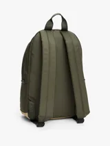 Mochila Tommy Jeans Essential color verde militar con base color beige. Tiene un compartimento principal con cierre, un bolsillo frontal con cierre, asa superior y correas acolchadas ajustables.