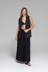 Chaleco largo de crepé negro con finas rayas verticales blancas, de corte sastrero y sin mangas.