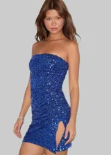 Vestido corto strapless azul eléctrico con lentejuelas y abertura lateral en la pierna.