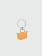 Llavero Longchamp con dije de bolso Le Pliage color naranja y aro metálico plateado.