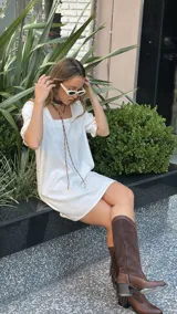 Vestido corto blanco de corte evasé, con escote cuadrado y mangas cortas abullonadas.