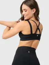 Top deportivo negro con escote cruzado y tirantes dobles.