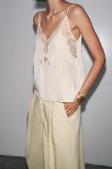 Top color crema de Zara Woman Collection, con escote pico, tirantes finos ajustables y detalle de encaje a tono.