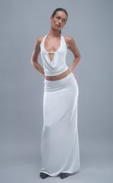 Conjunto de top halter con escote drapeado y falda larga ajustada, ambos de color blanco.