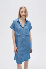 Vestido camisero azul de viscosa, corte recto, largo a la rodilla, con cuello camisero, manga corta con dobladillo, cierre frontal con botones y dos bolsillos de parche en el pecho.