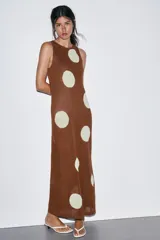 Vestido midi de tejido de punto color marrón, sin mangas y con cuello redondo. Presenta un estampado de lunares grandes en color crema/blanco roto.
