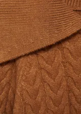 Sweater marrón de punto grueso trenzado con cuello polo amplio y mangas largas.