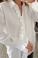 Camisa blanca de manga larga con volados en el frente y en los puños.