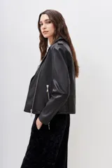 Campera de cuero ovino color negro, corte motoquero con charreteras y solapas. Cierres metálicos plateados en puños, frente y bolsillos.
