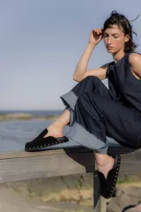 Zuecos de gamuza color marrón chocolate, con base de goma negra, tachas plateadas alrededor de la base y plantilla acolchada.