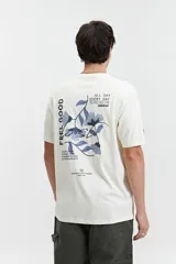Remera color crudo de manga corta con cuello redondo y estampado en la espalda con flores azules y texto.