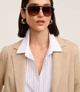 Blazer regular de sastrería color beige, con cuello solapa, sin botón, con bolsillos y detalle de pliegues en las mangas.