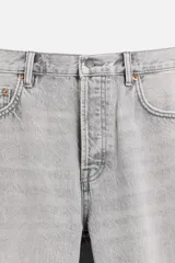 Pantalón de jean gris de corte recto, con cinco bolsillos, efecto lavado y cierre frontal con botones.