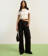 Pantalón de vestir negro, de corte recto, con trabillas en la cintura y elástico en la parte trasera.