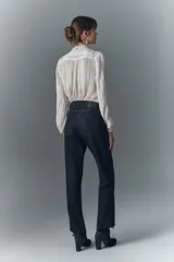 Pantalón de jean negro con corte recto y detalles brillantes.