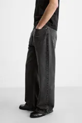 Pantalón de jean celeste con efecto lavado, corte flare fit y caída baggy desde la rodilla hasta el tobillo. Tiene cinco bolsillos y cierre frontal con botones.