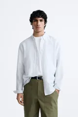 Camisa celeste a rayas verticales, de corte relaxed fit, confeccionada en lino y algodón. Tiene cuello abotonado, manga larga con puños abotonados, bolsillo de parche en el pecho y cierre frontal con botones.