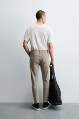 Pantalón de jean color beige, corte skinny, tiro medio, largo cropped y cinco bolsillos.