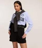 Short de sastrería color verde oliva, de corte recto y cintura alta. Presenta pliegues frontales y un detalle de medio cinturón con hebilla lateral.