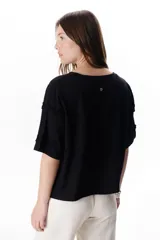 Chaqueta color beige con escote en V y cierre frontal con lazos. Presenta mangas cortas con volados.