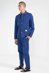 Chaqueta azul con textura seersucker, cuello con solapa, cierre con botones, bolsillo en el pecho y dos bolsillos de parche redondeados.