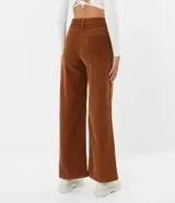 Pantalón pantalona acampanado color marrón de pana con bolsillos delanteros y traseros.