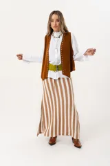 Falda larga tejida a rayas verticales color beige y blanco, con pretina elástica y tajos laterales.