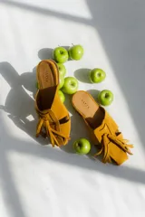 Zuecos negros con diseño de tiras entretejidas y suela plana color madera.