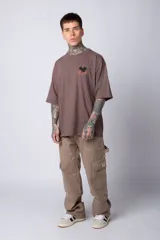 Remera blanca de algodón de corte oversize con mangas cortas y cuello redondo. Presenta un pequeño estampado en el frente con la figura de Mickey Mouse y caracteres orientales.