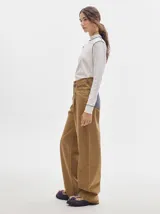 Polera negra de tela rib con cuello alto y mangas largas. Presenta pespuntes rojos en cuello, hombros y puños.