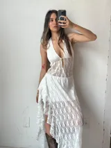 Vestido largo blanco de encaje con escote halter y espalda descubierta.