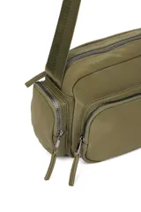 Bandolera color crudo con correa ajustable, bolsillo frontal con cierre y bolsillos laterales con cierre.