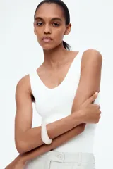 Musculosa de punto fino color blanco, entallada con escote en U adelante y atrás.