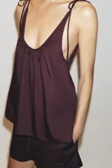 Top azul de popelina con escote redondo, tirantes finos con lazadas y detalle de pliegues.
