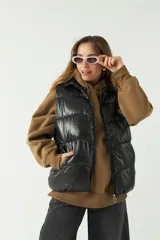 Chaleco puffer color crema con textura acolchada y bolsillos con cierre.