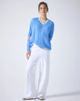 Sweater de cashmere color lila con cuello en V, corte oversize, mangas largas, hombros caídos y terminaciones acanaladas.