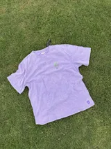 Remera lila con estampa de un jarrón con flores.
